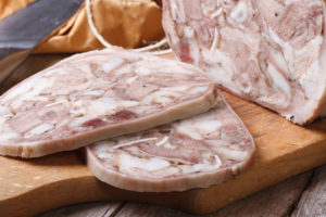 Coppa di testa affettata su un tagliere di legno; concept: Listeria