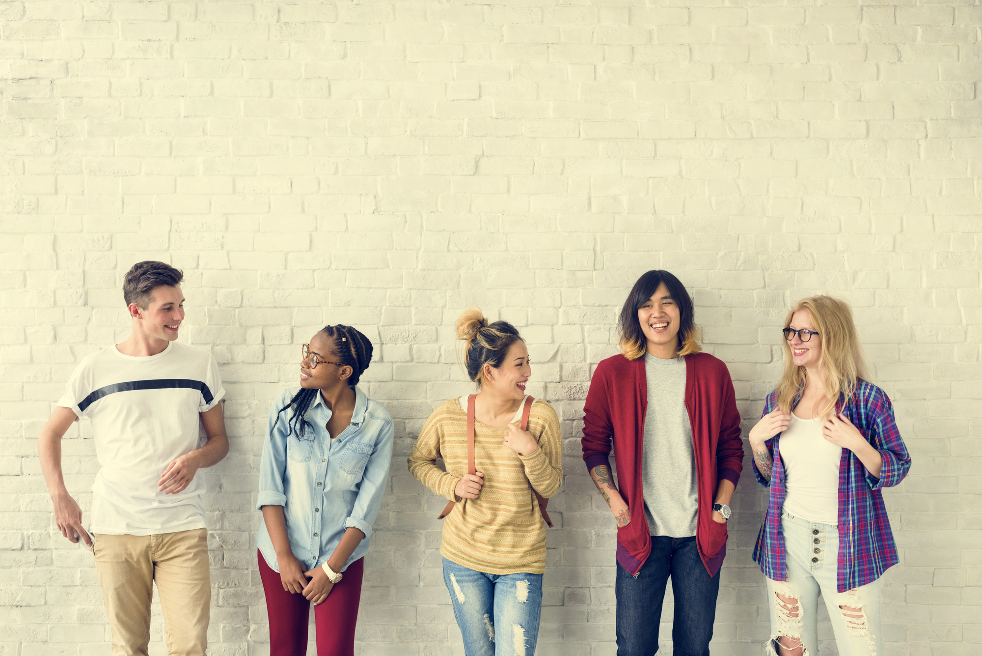gruppo di ragazzi e ragazze appoggiati a un muro