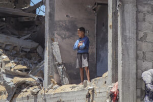 Un ragazzino osserva in piedi dalle rovine di un edificio