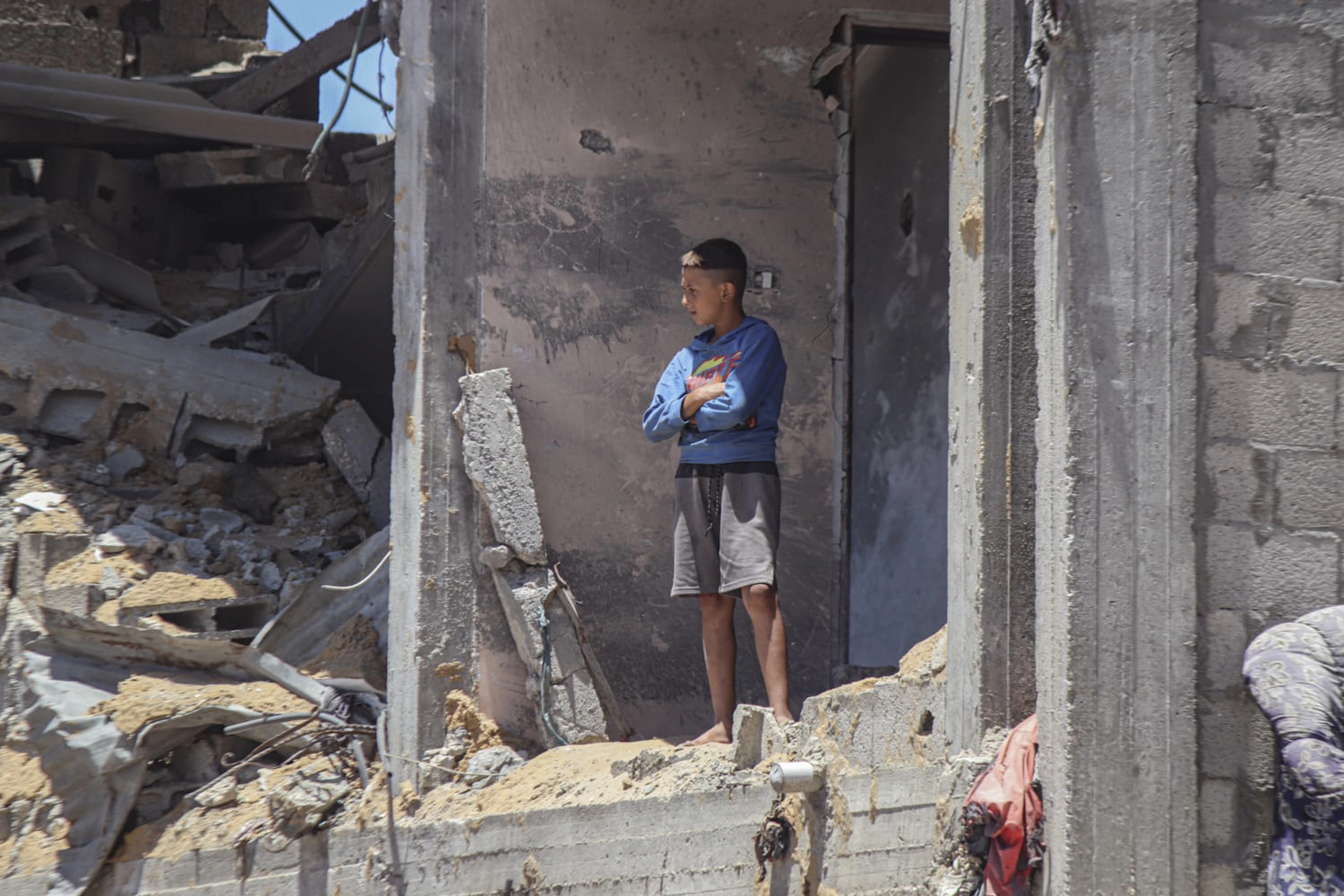 Un ragazzino osserva in piedi dalle rovine di un edificio