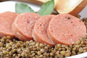 Fette di cotechino o zampone su lenticchie in umido