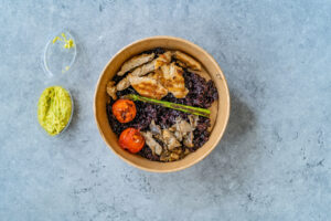Bowl di riso nero, con pollo arrosto, funghi e pomodori, con ciotolina di guacamole; concept: insalata di riso, poké