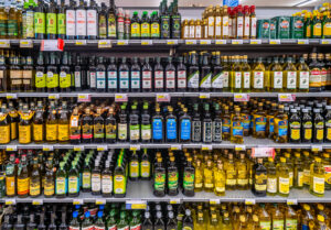 Scaffale dl supermercato carico di bottiglie di olio extravergine di oliva