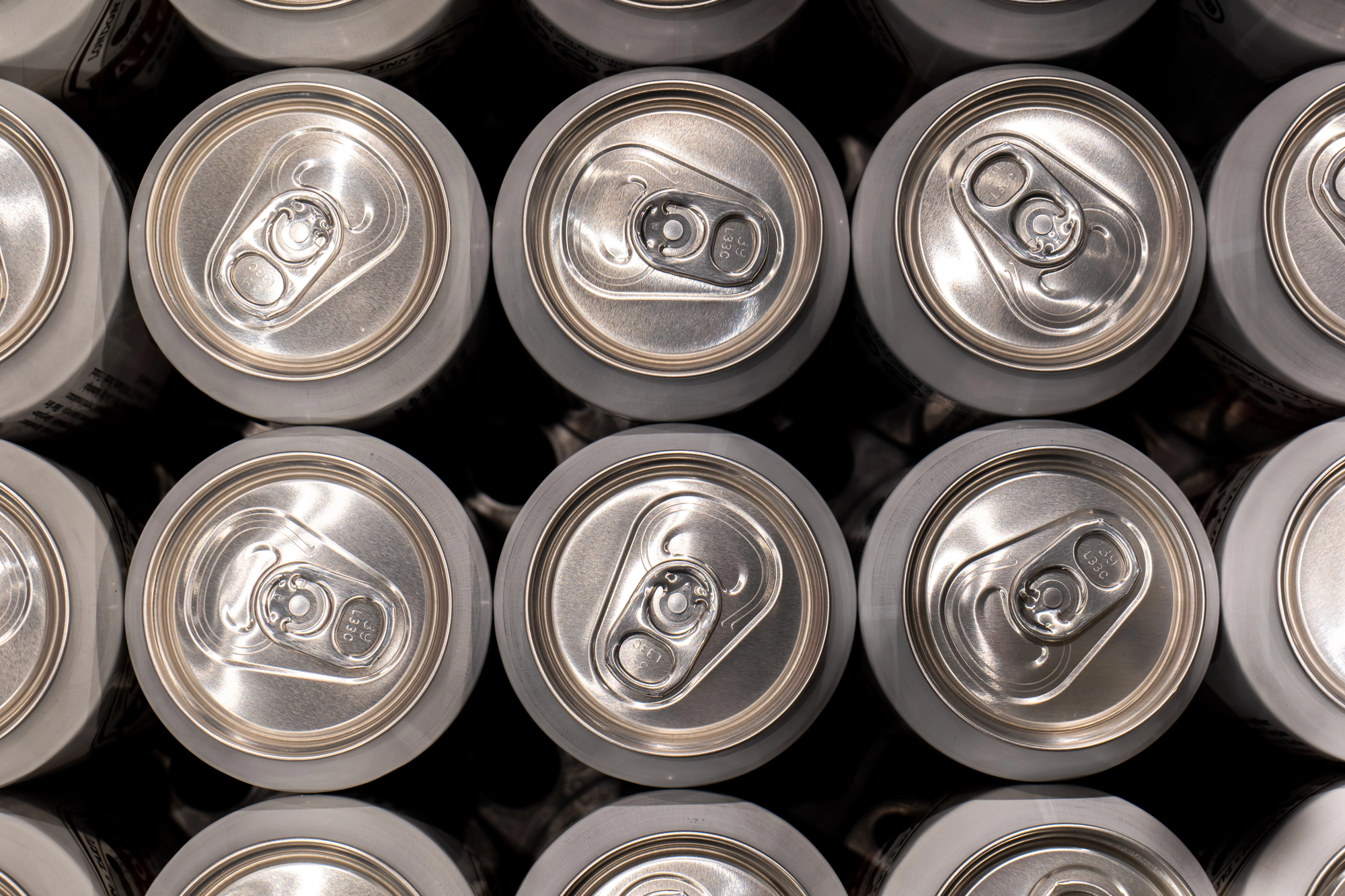 Lattine di alluminio viste dall'alto; concept: bibite, bevande zuccherate, bevande alcoliche, energy drink, bisfenolo A