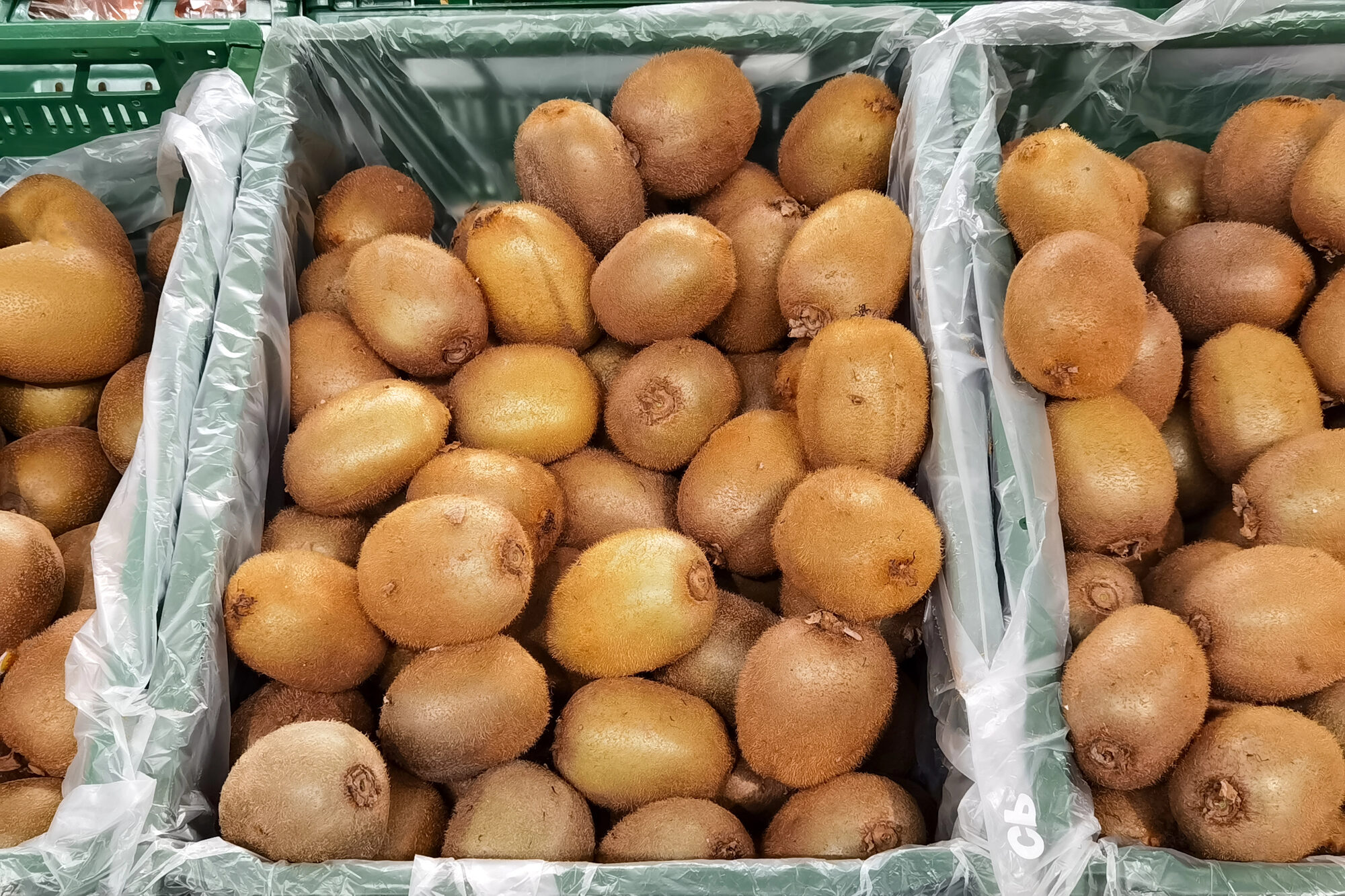 Cassette di kiwi nel reparto ortofrutta di un supermercato; concept: frutta tropicale